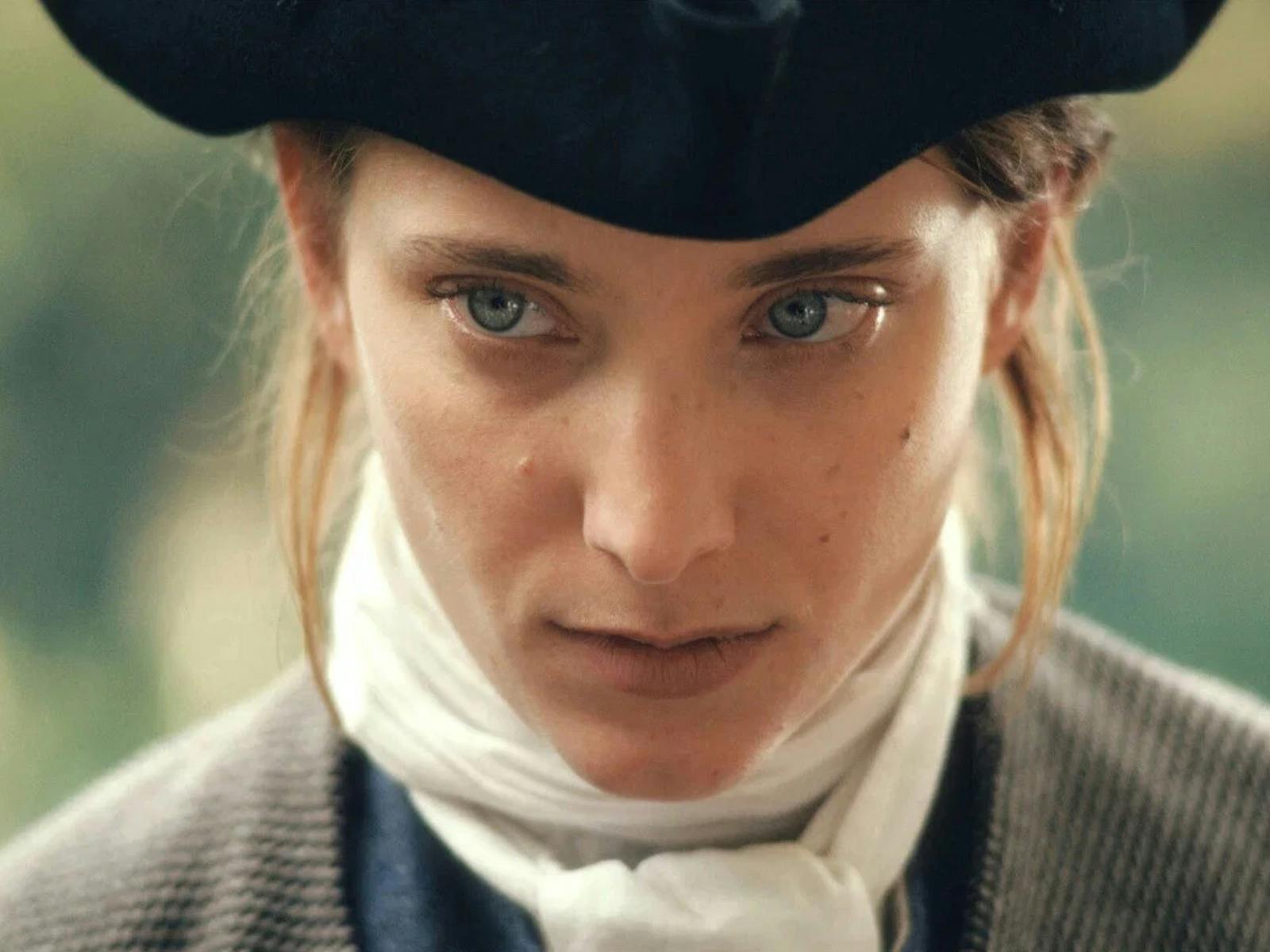 Close up of person wearing hat, blue eyes and white cravat