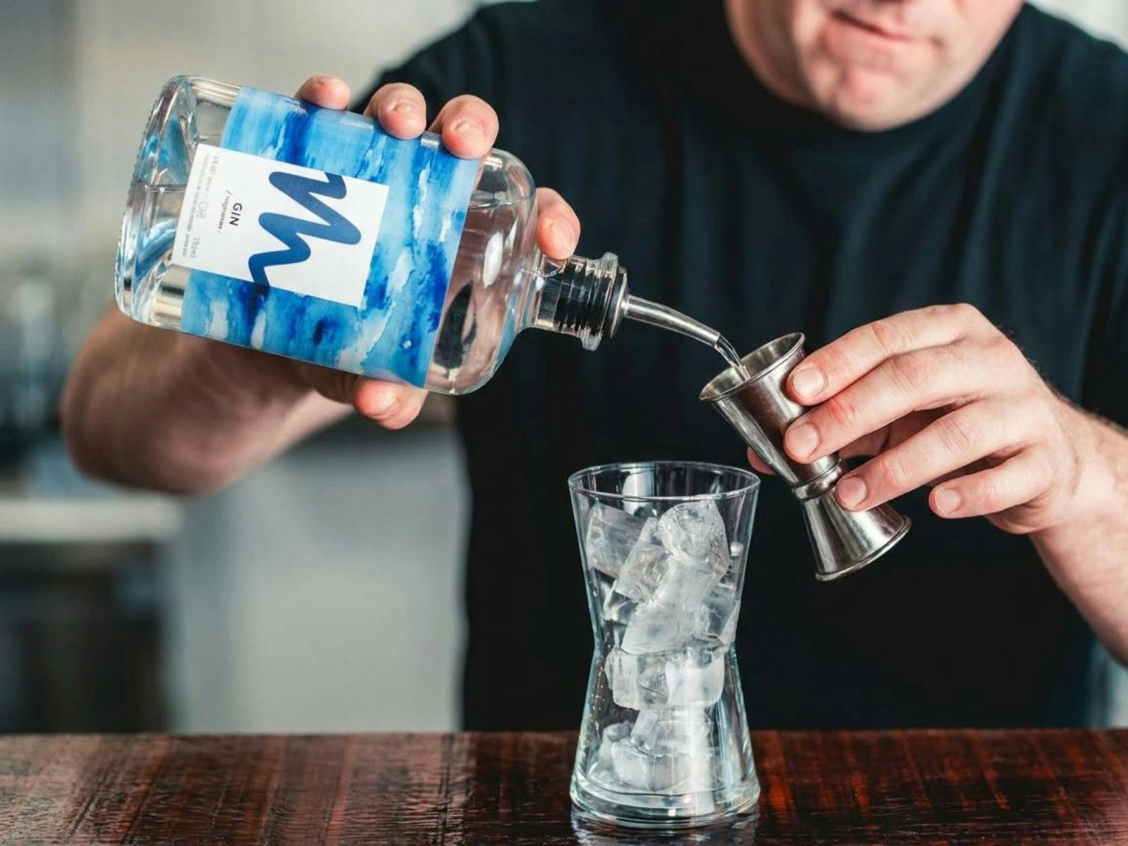 Pouring gin into a measurer