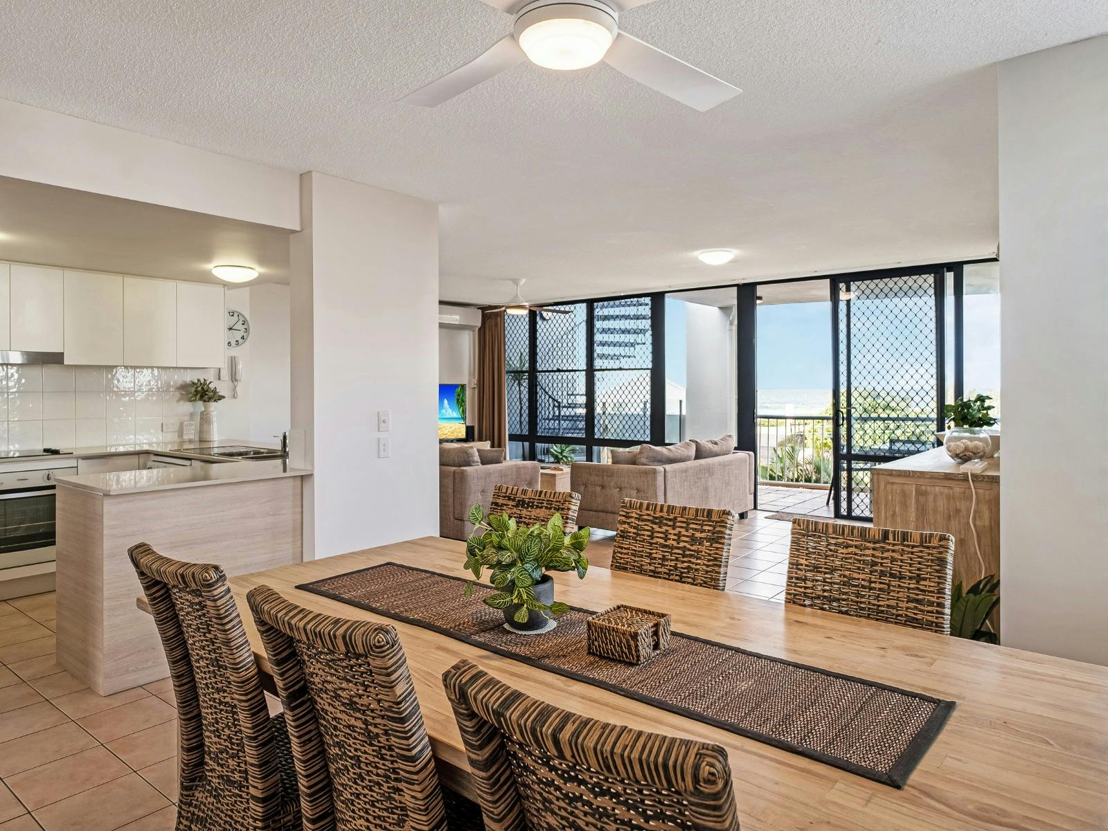 Open plan dining, kitchen and lounge area with balcony access