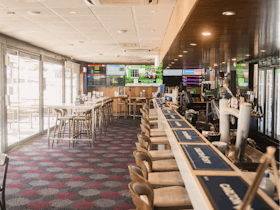 Spacious bar interior with multiple screens showing live sports at the Pastoral Hotel Motel.