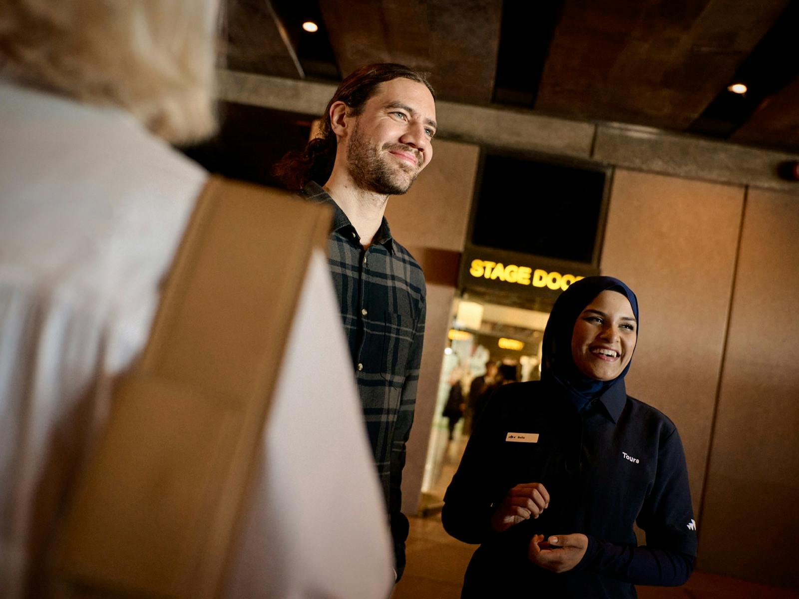 ステージドアの外で微笑むツアーガイドと男性