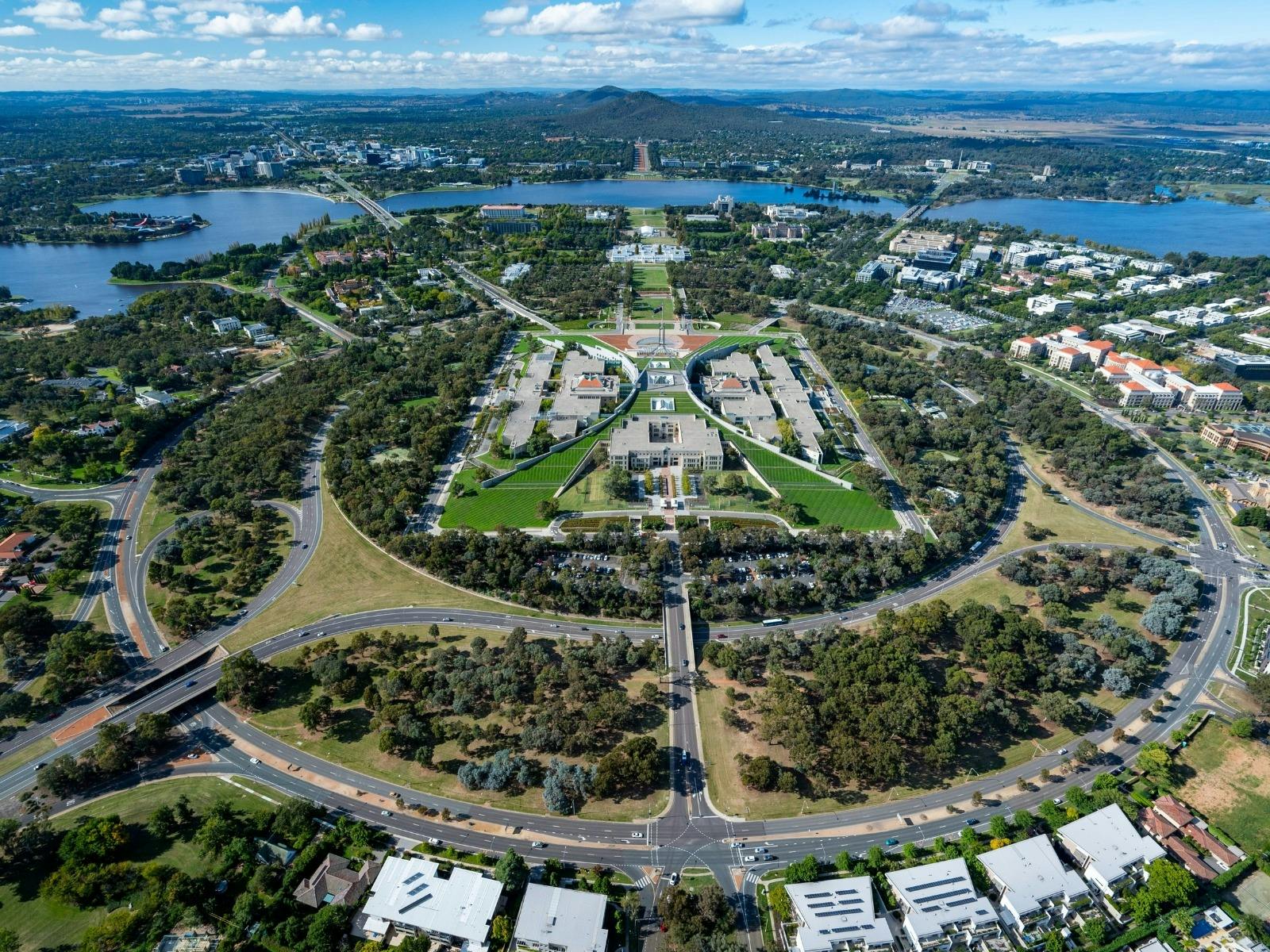 An aerial view shows the capital city with its buildings, streets, and surrounding landscape.