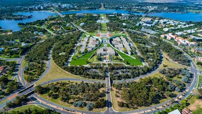 An aerial view shows the capital city with its buildings, streets, and surrounding landscape.