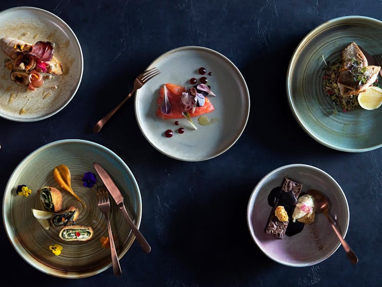 Selection of dishes on plates with copper utensils