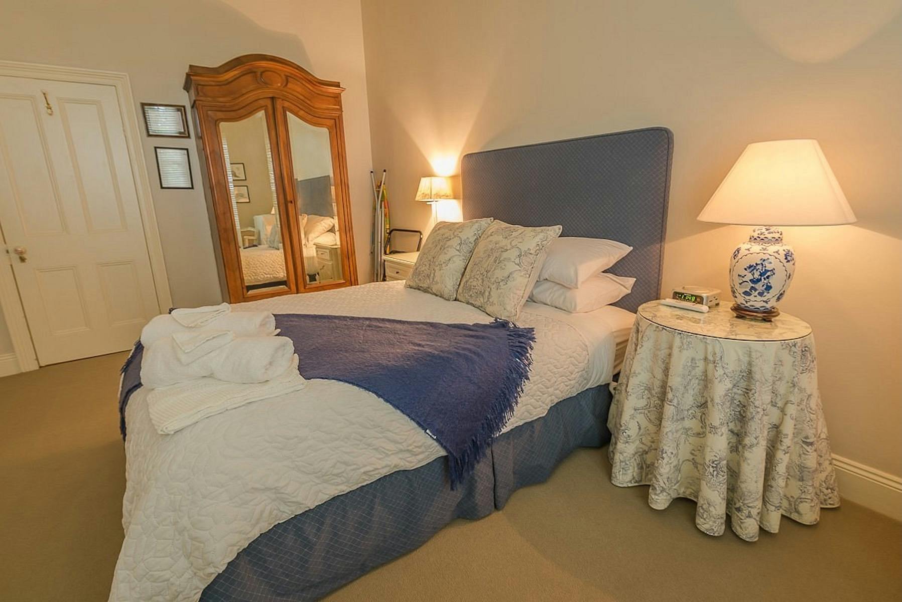 Blue Room with king bed, fresh towels, antique wardrobe and warm lighting