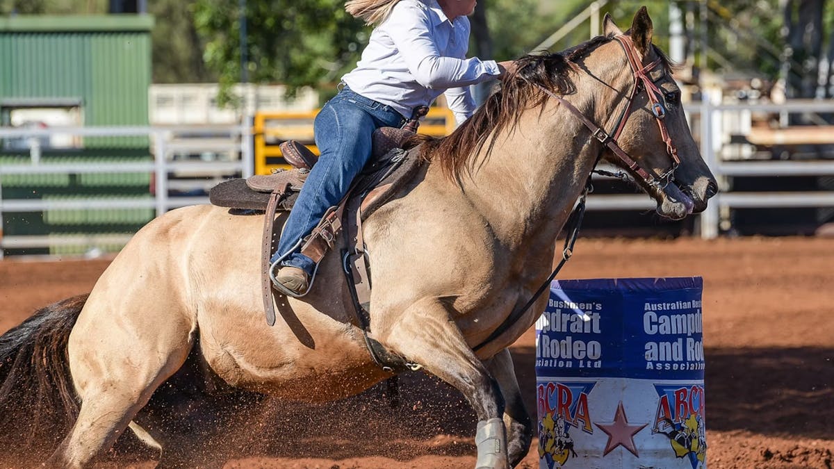A woman competes in a horse barrel race at the Chillagoe Rodeo.