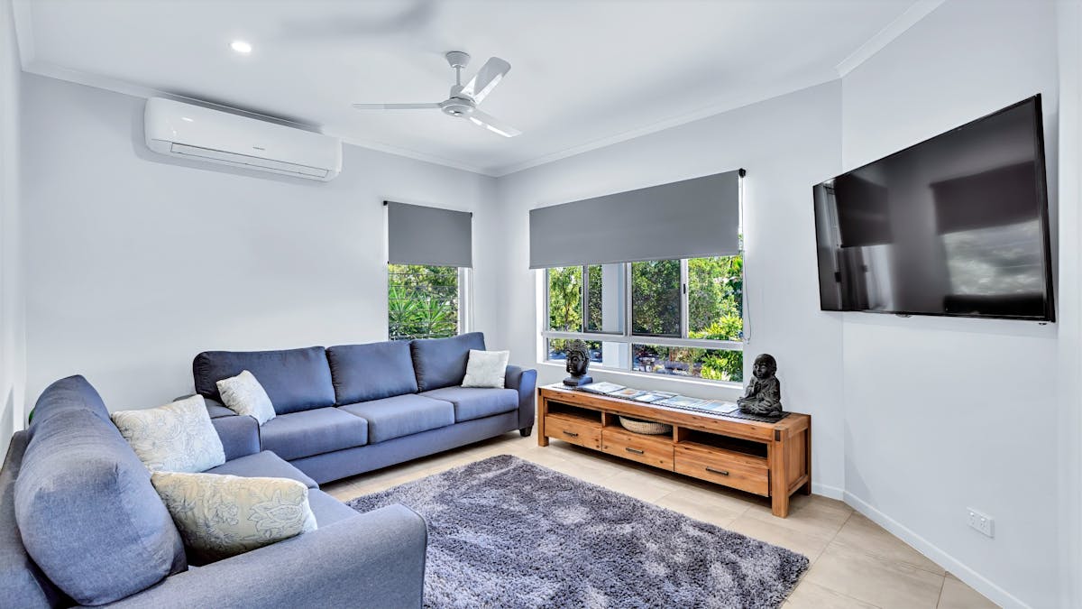 “Family-friendly holiday home living room with sofa, TV and air conditioning in Hideaway Bay