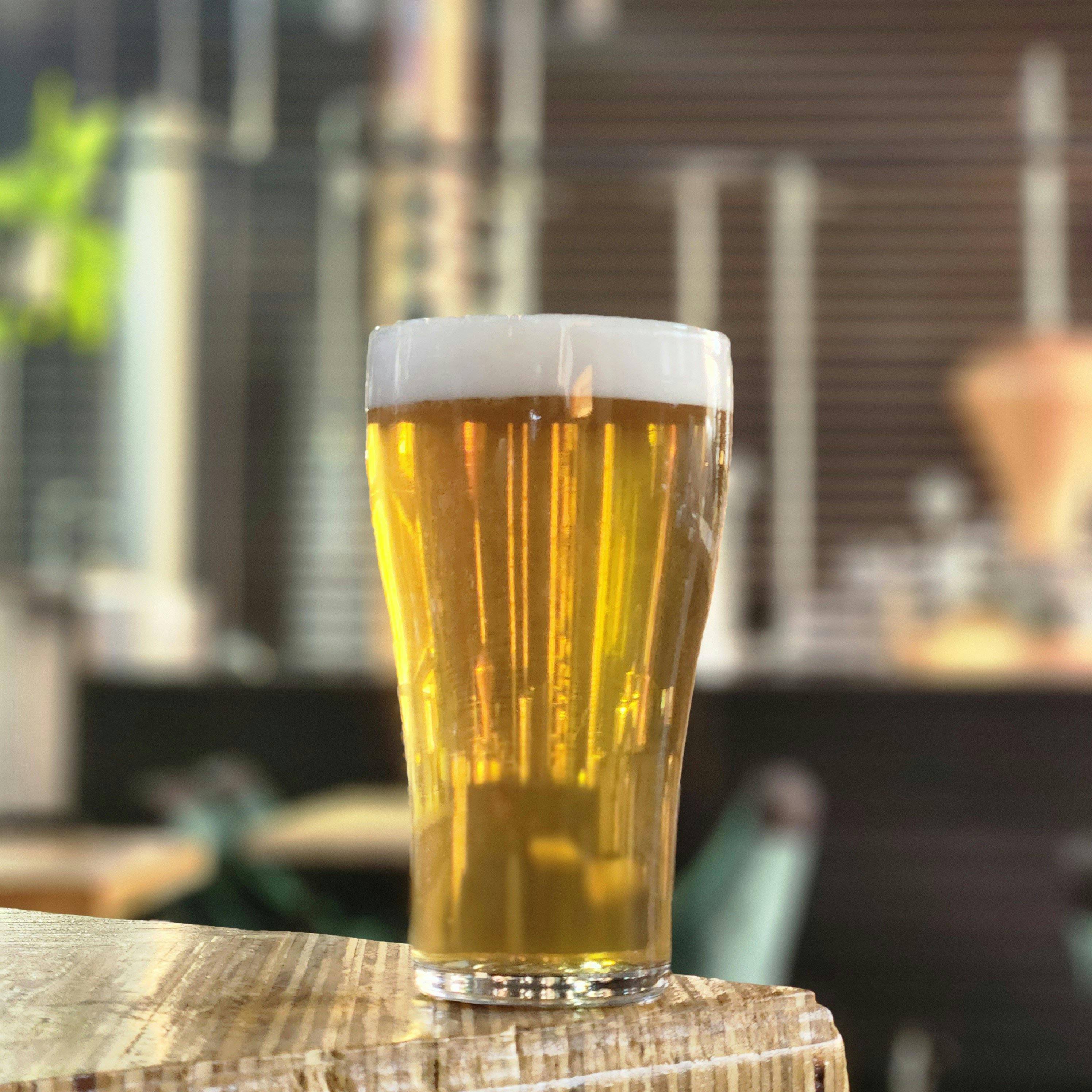 Ein großes Bierglas steht am Rand der Bar.