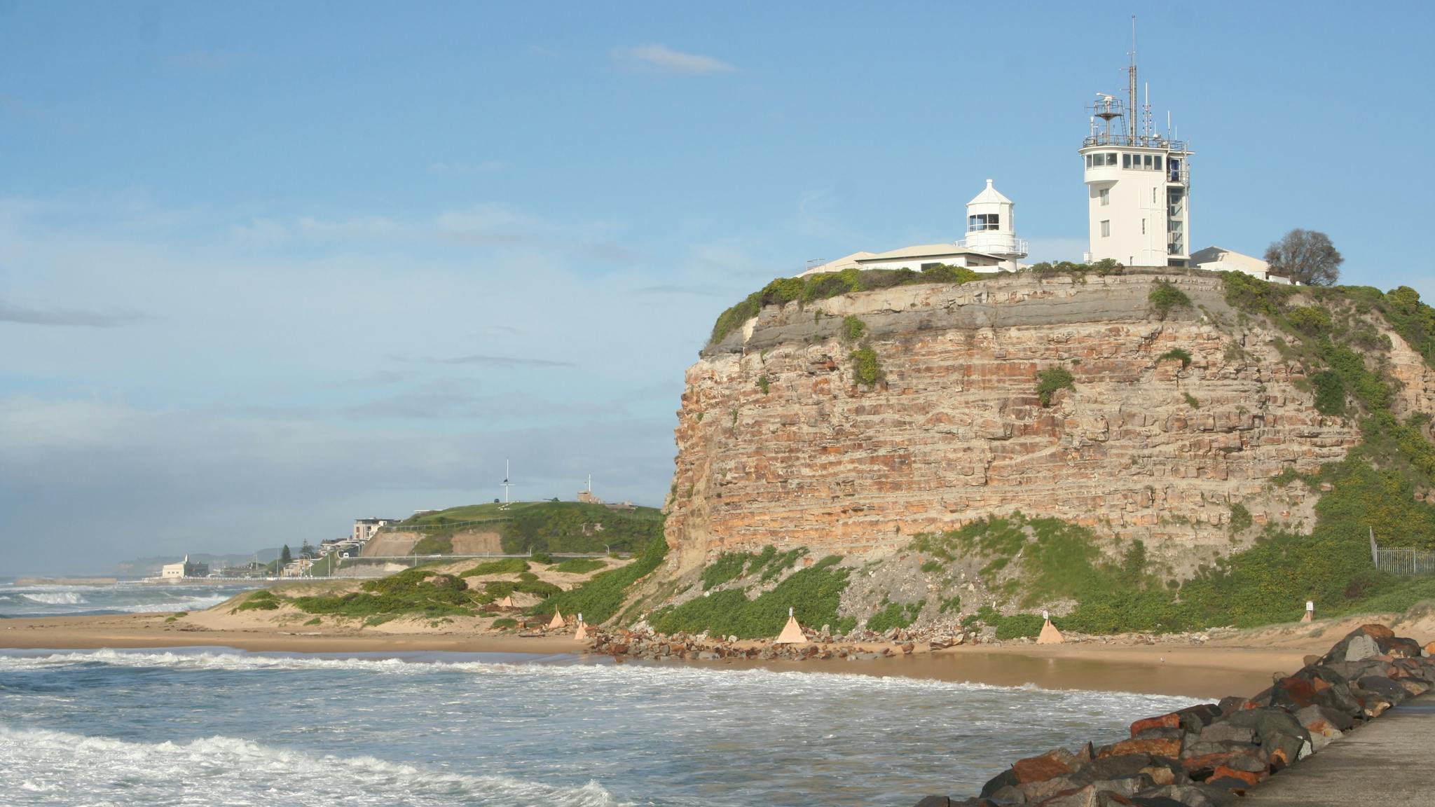 A headland in Newcastle with a lighthouse on top