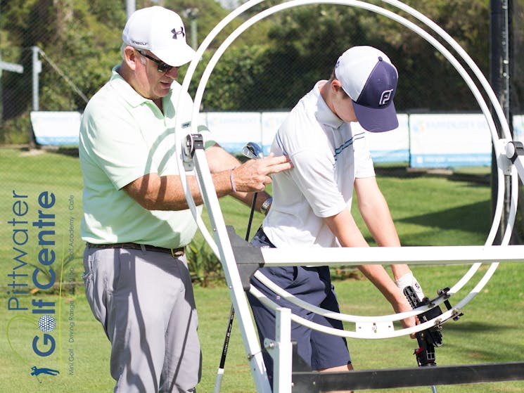 Pittwater Golf Centre - PGA Professional Trainer Dave Saunders teaching student with training aid