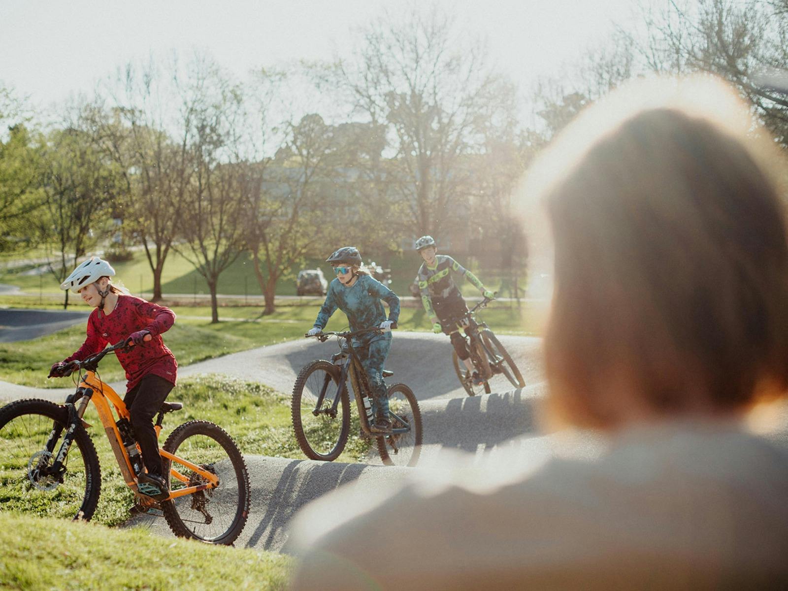 kids on pump track with bikes