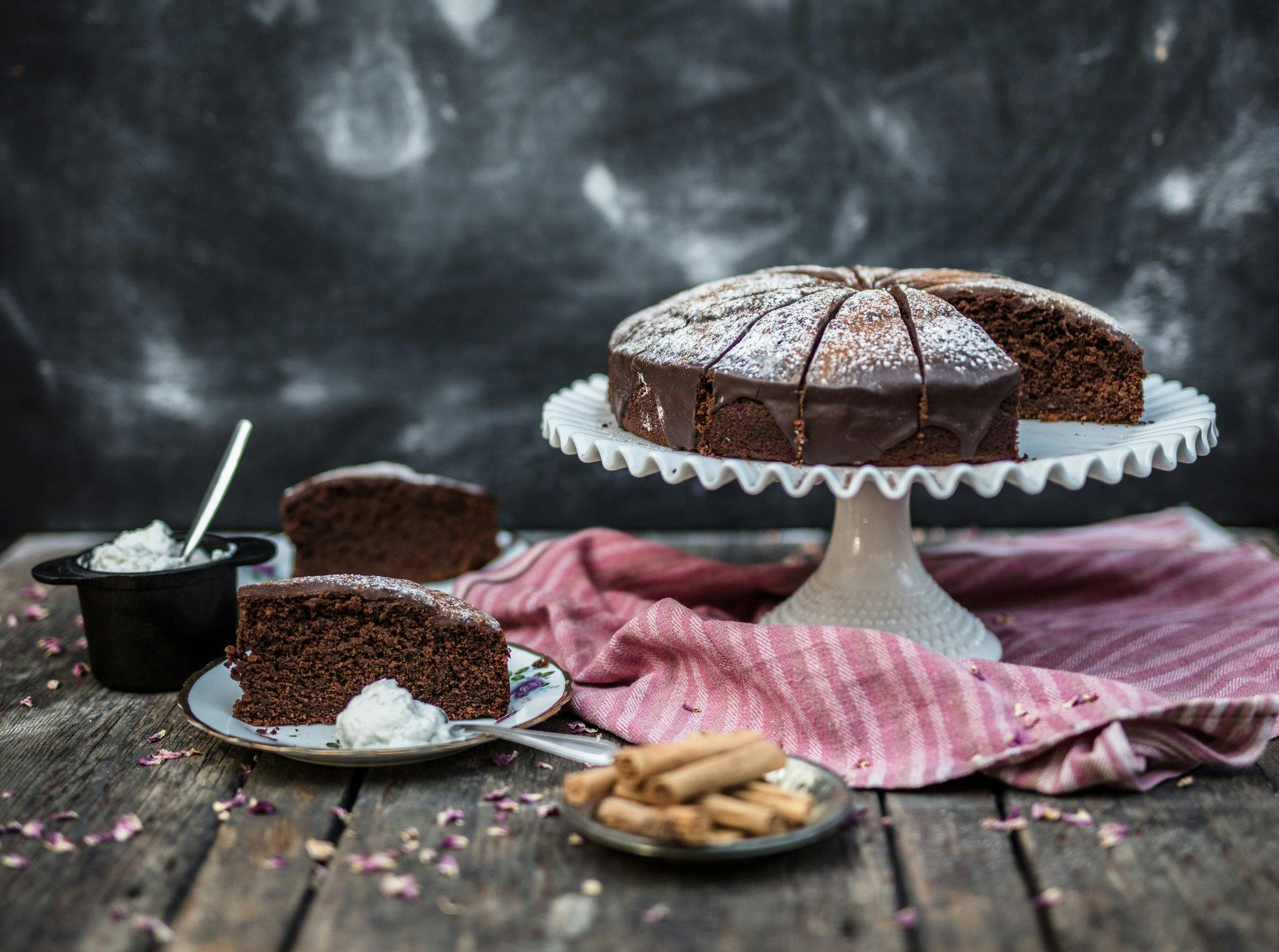 Chipotle Chocolate Cake on a stand and a few slices on plates.