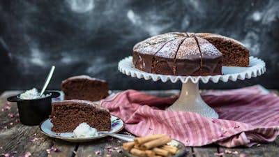 Chipotle Chocolate Cake on a stand and a few slices on plates.