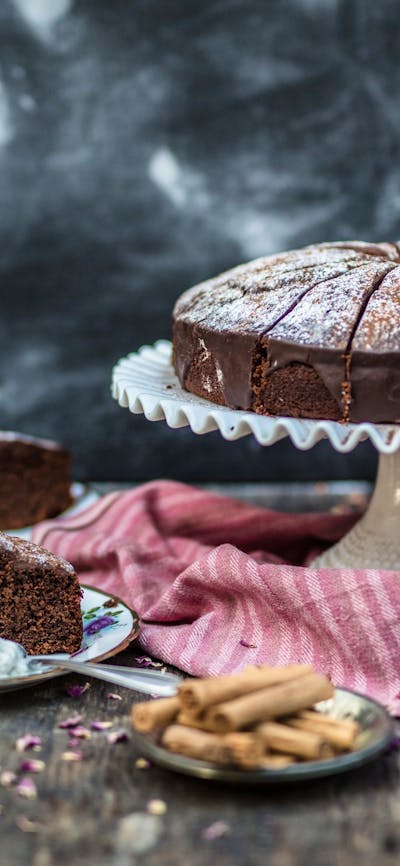 Chipotle Chocolate Cake on a stand and a few slices on plates.