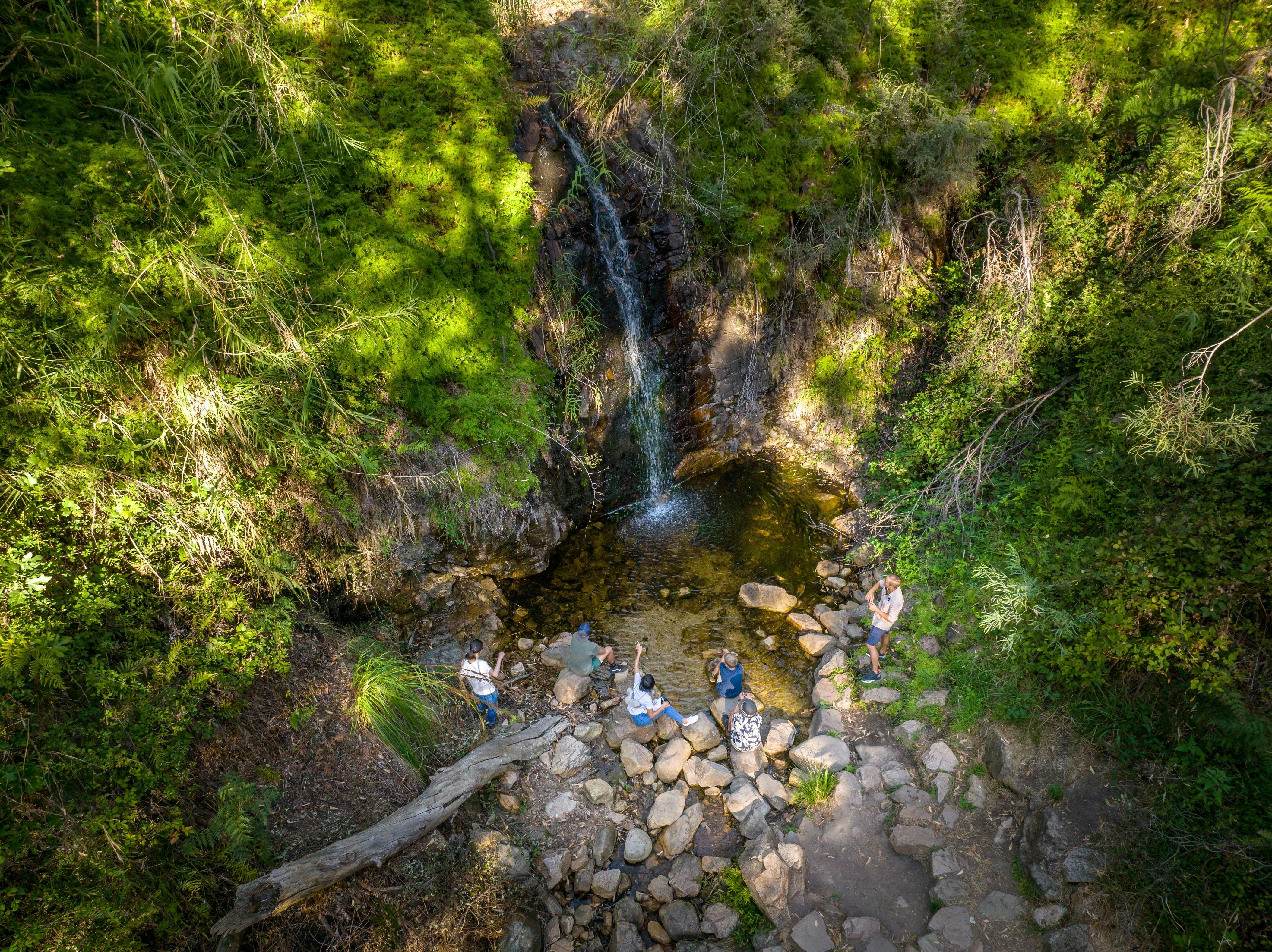tour guide leads hikers up to the waterfall