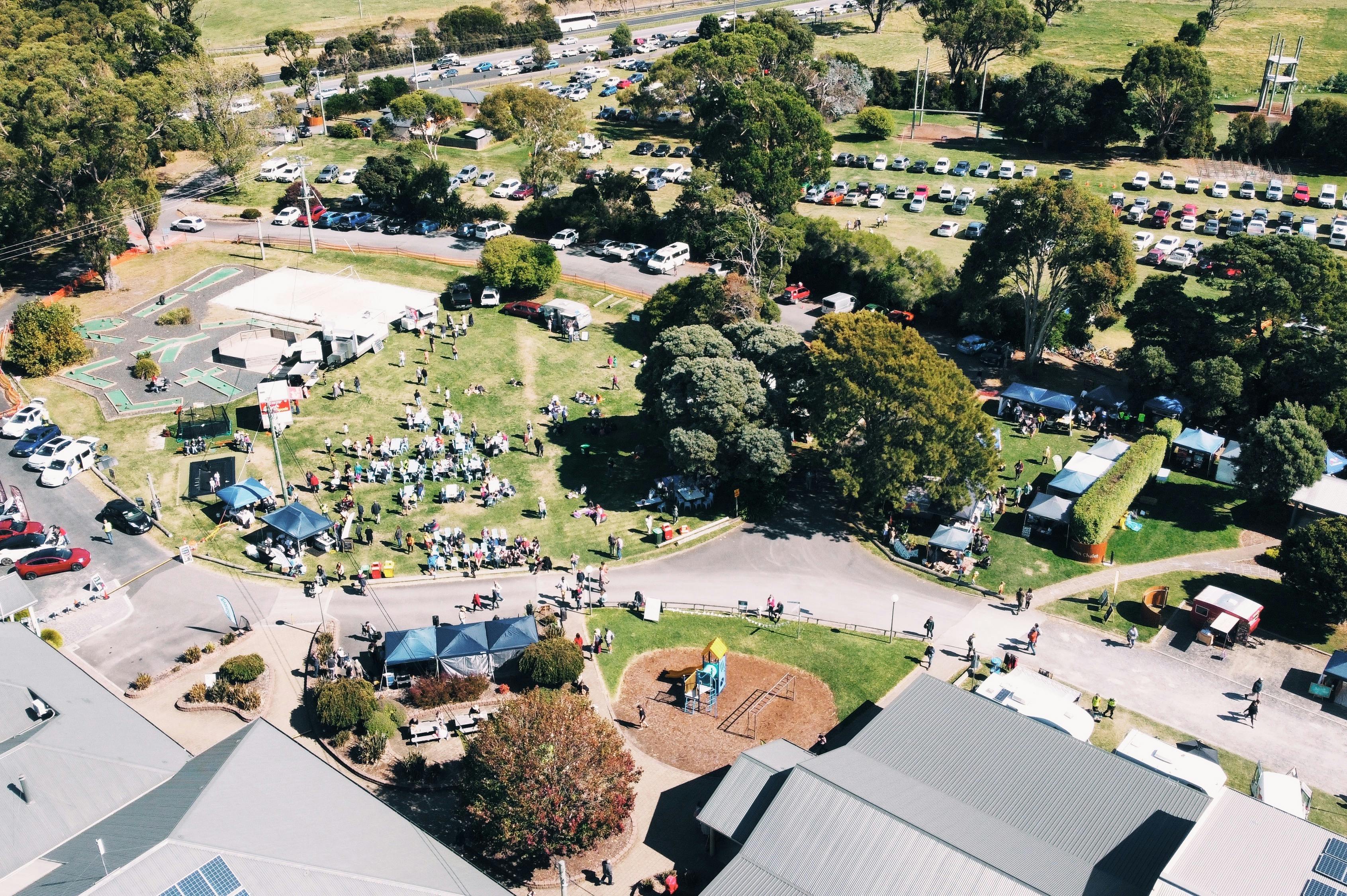 Aerial view of NW EcoFest showing stalls, food trucks, families, and community activities.