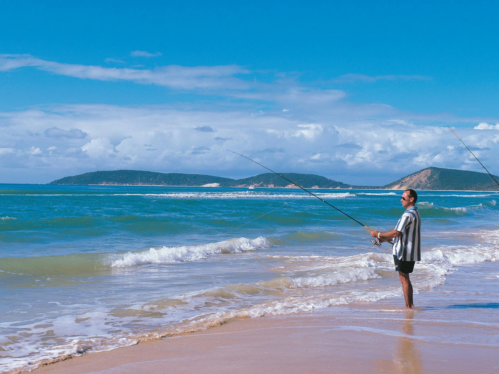 Couple fishing from beach, Rainbow Beach