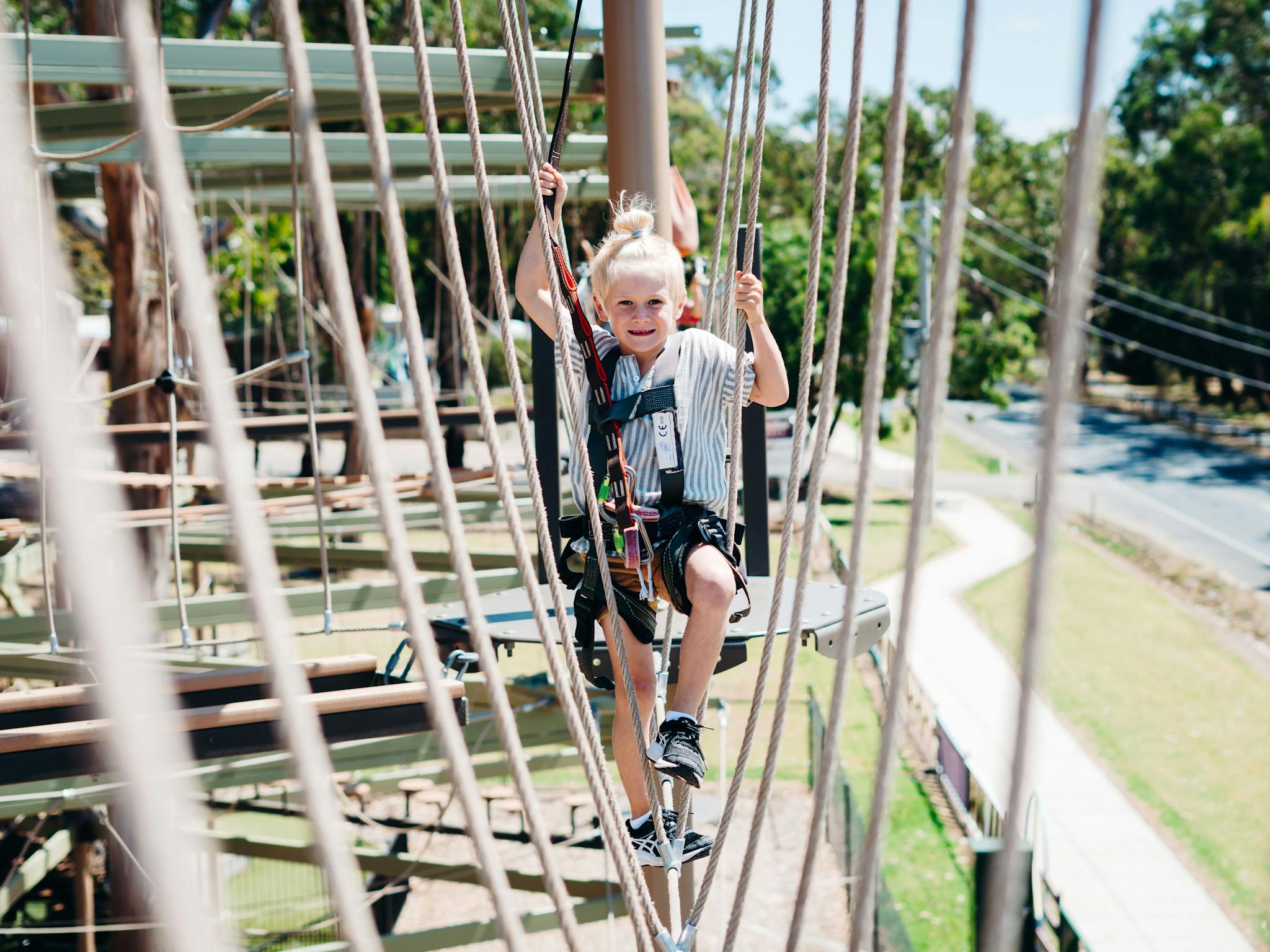 Child climbing on the adventure high ropes course at A Maze'N Things