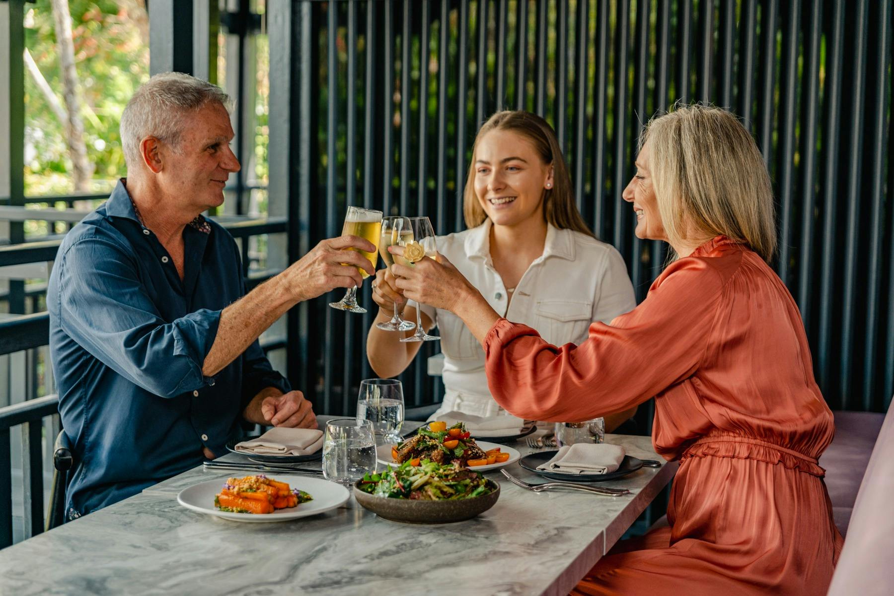 A family dining at The Balfour Kitchen & Bar holding drinks