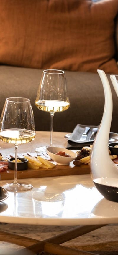 Wine and cheese laid out on a table with wine decanter