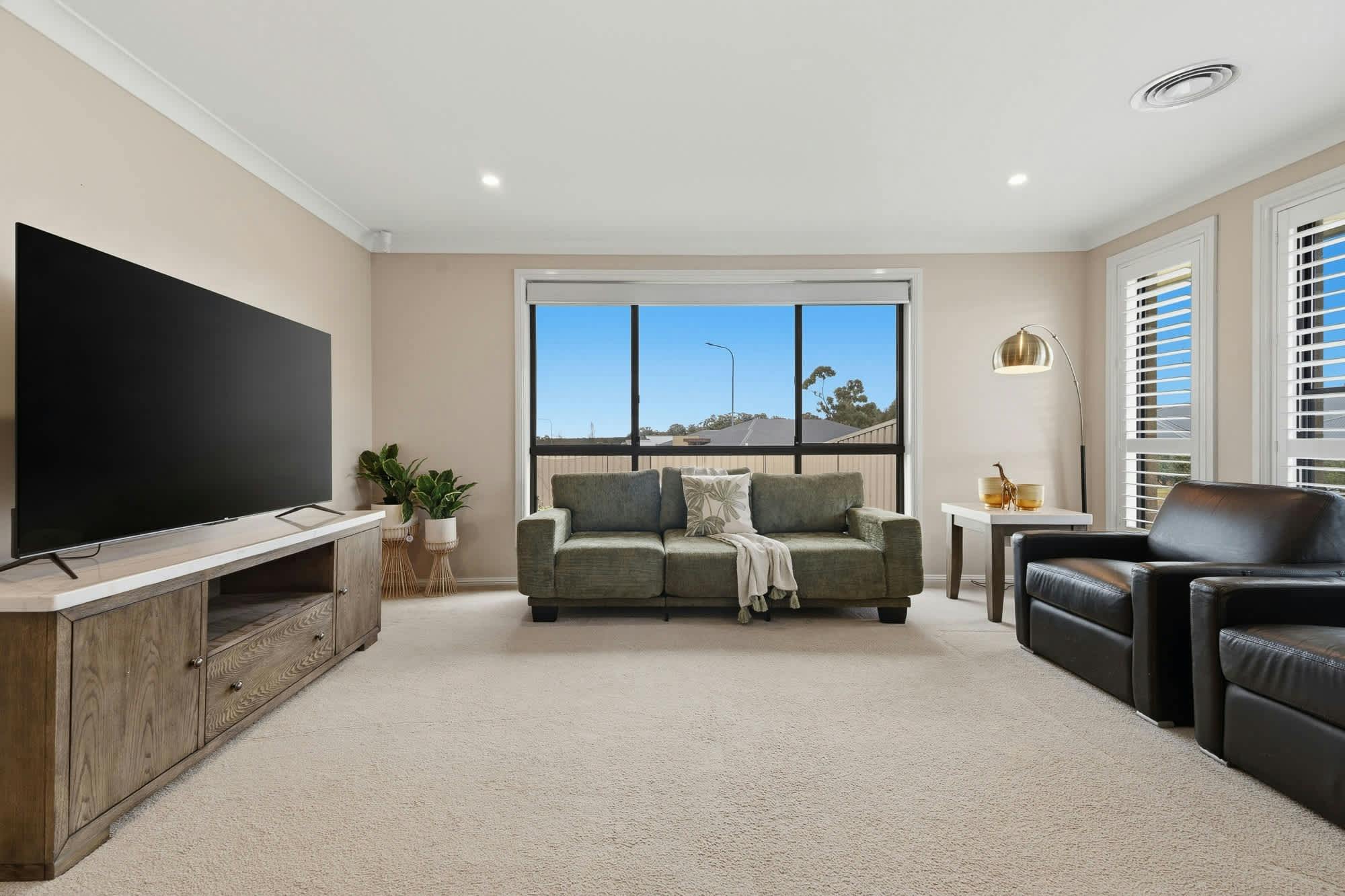 Lounge room with 2 couches, entertainment unit and tv