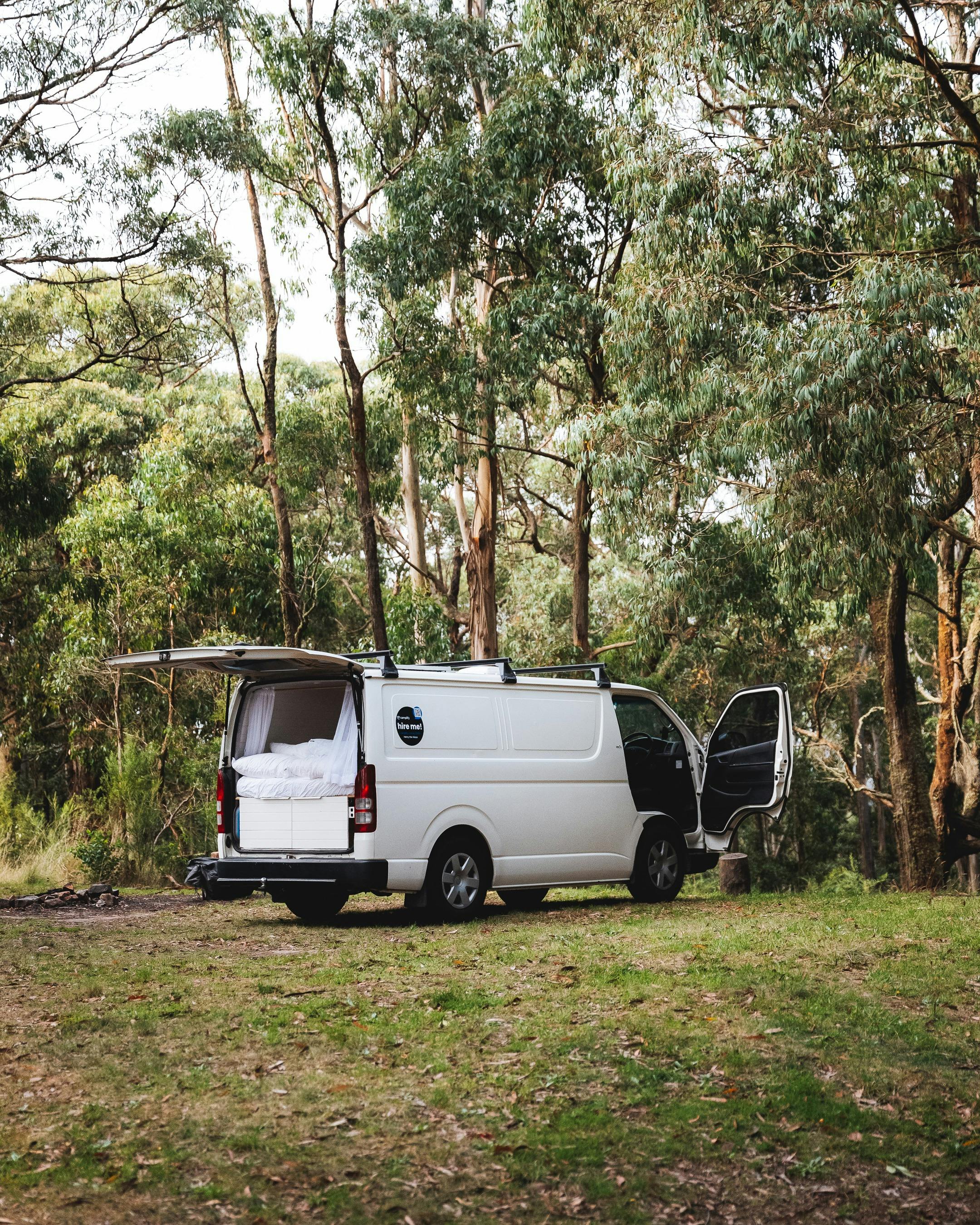 camper van with back door open in the forest