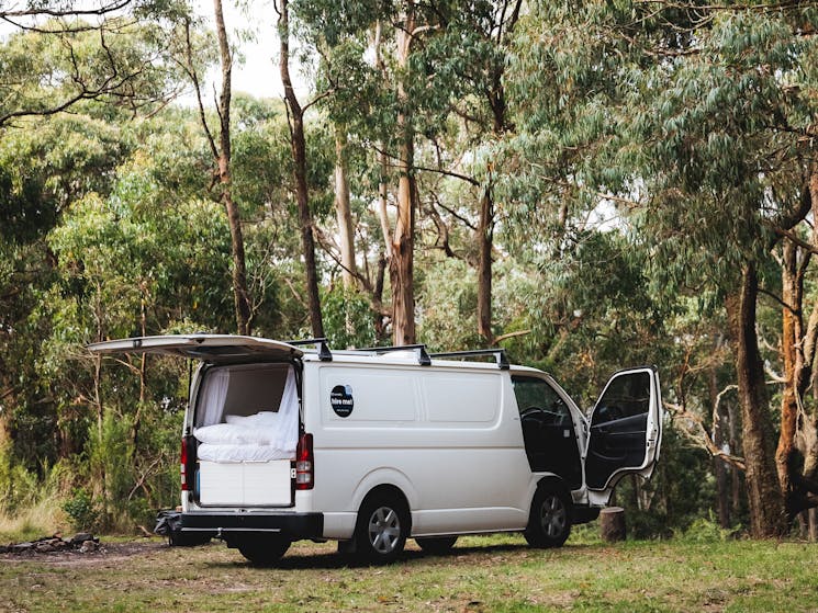 camper van with back door open in the forest