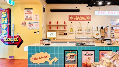 A bright and inviting interior of POP Canberra, featuring a checkout counter, merchandise.