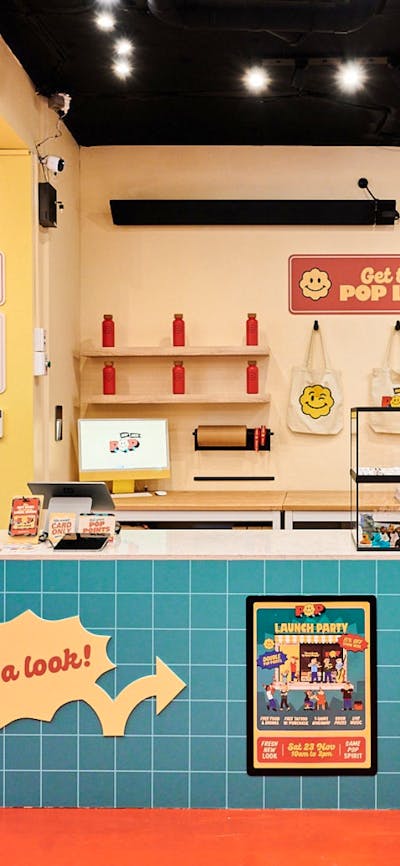 A bright and inviting interior of POP Canberra, featuring a checkout counter, merchandise.