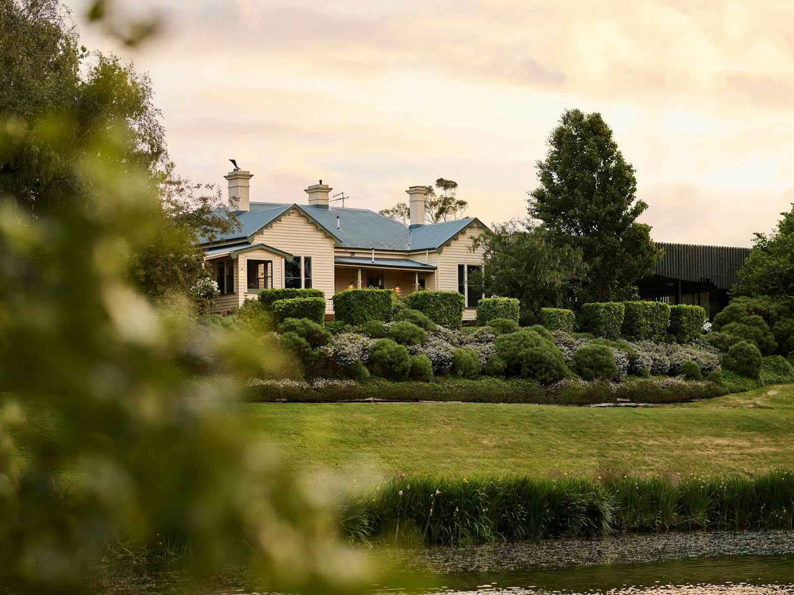 The 1880s homestead of Josef Chromy Wines Cellar Door, viewed across the lake and gardens