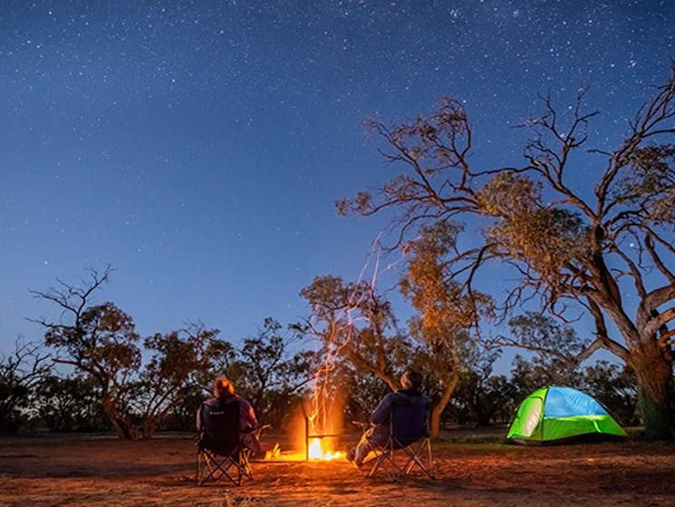 Campers stargazing by the fire at Emu Lake campground in Kinchega National Park. Photo: John