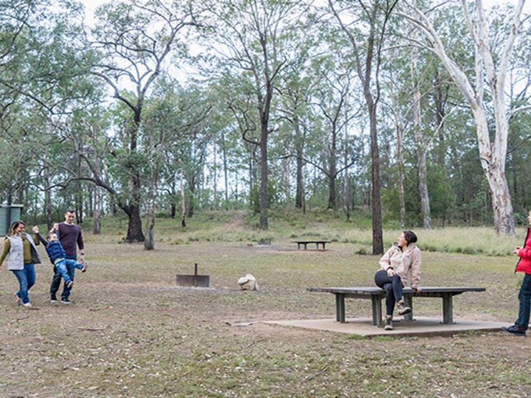Family enjoy a walk around the Bennett Ridge section of Euroka campground with toilets in the