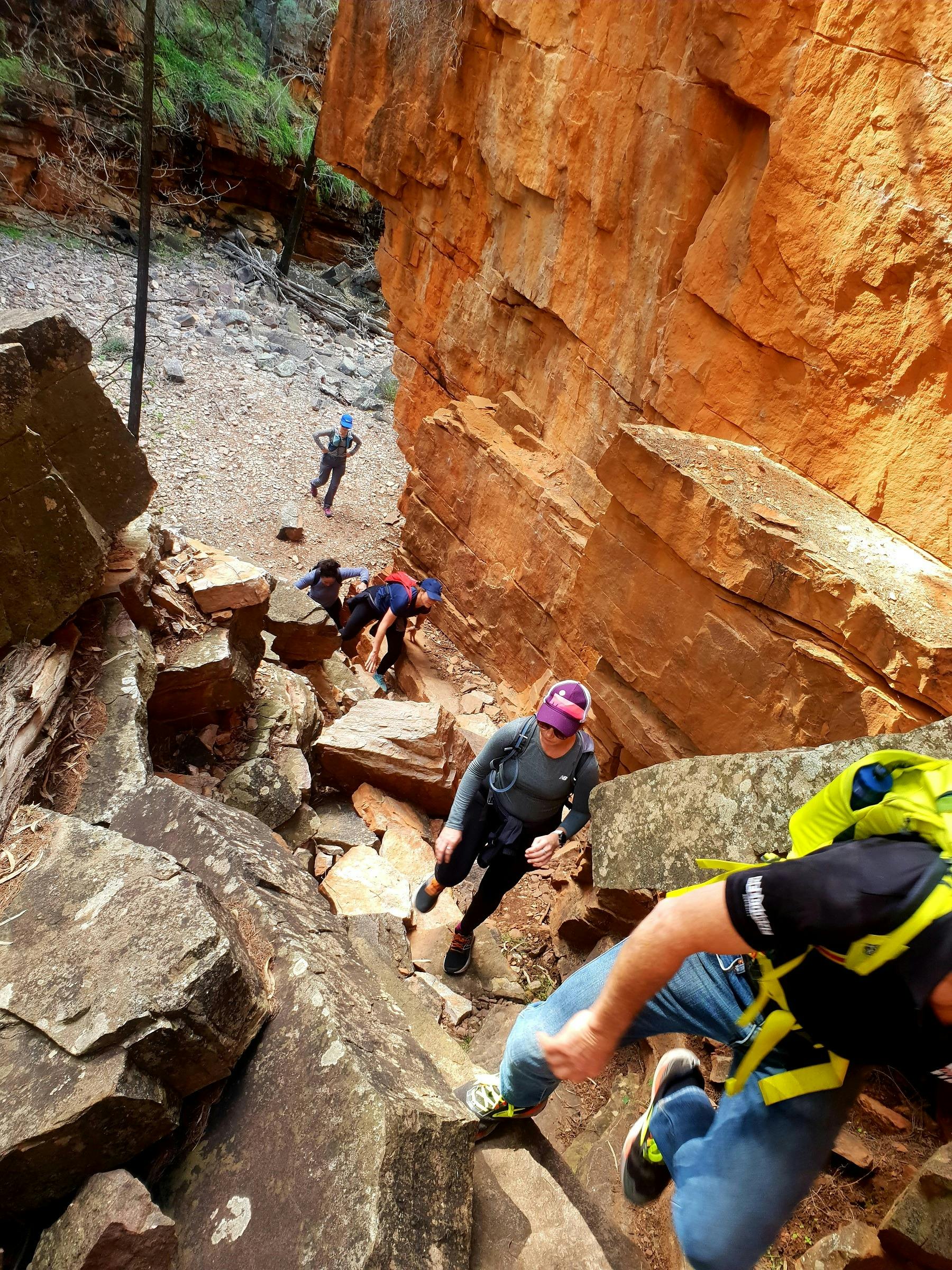 Group climbing up fallen rocks in Hidden Gorge