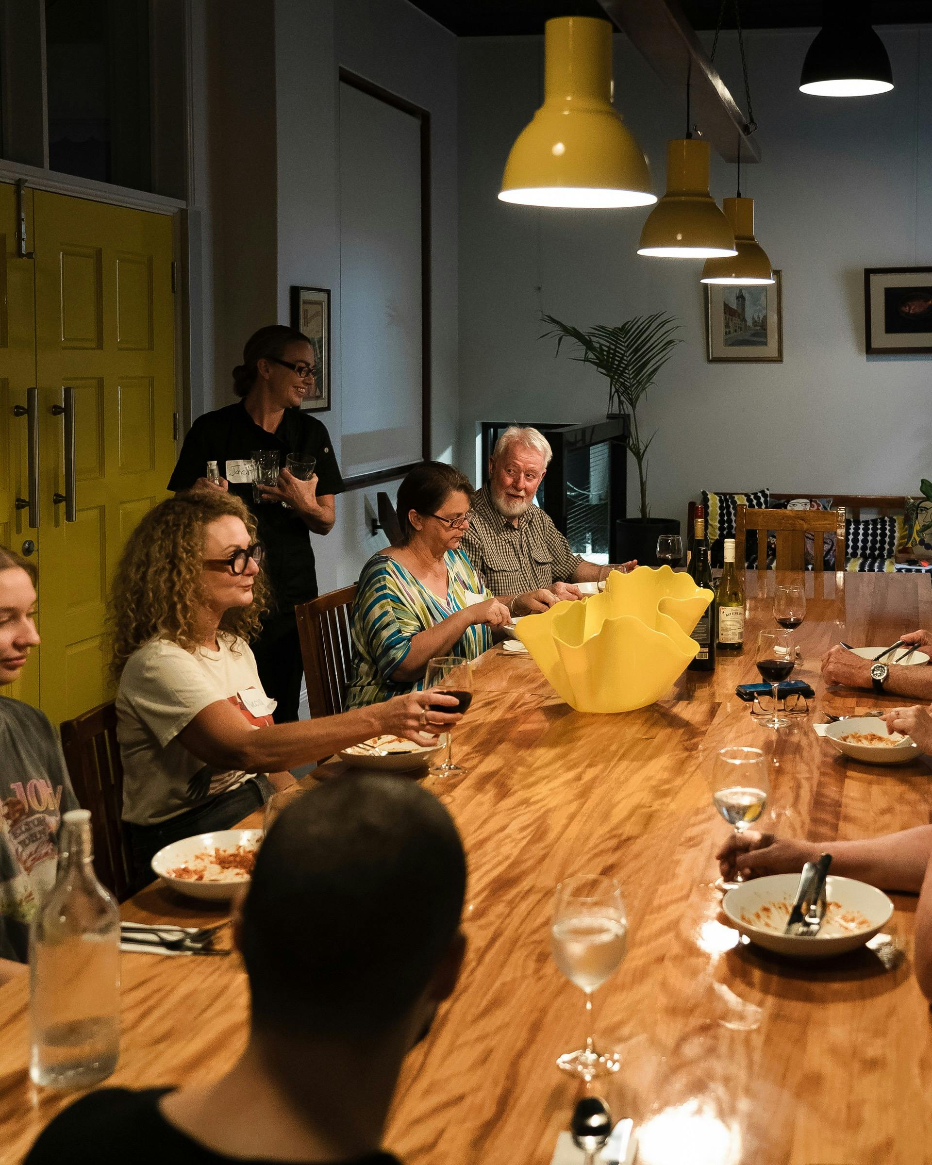 Photo of people siting at a dining table eating a meal