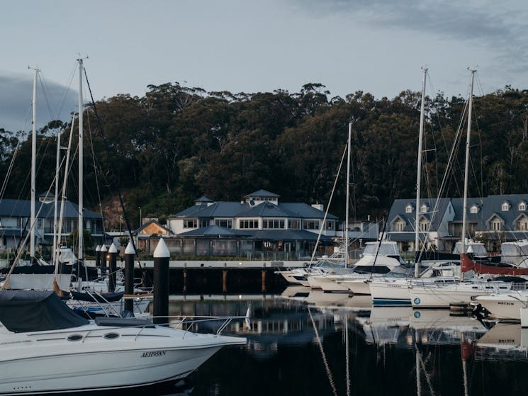 A shot of the exterior of the property, looking over the marina with boats moored in the harbour