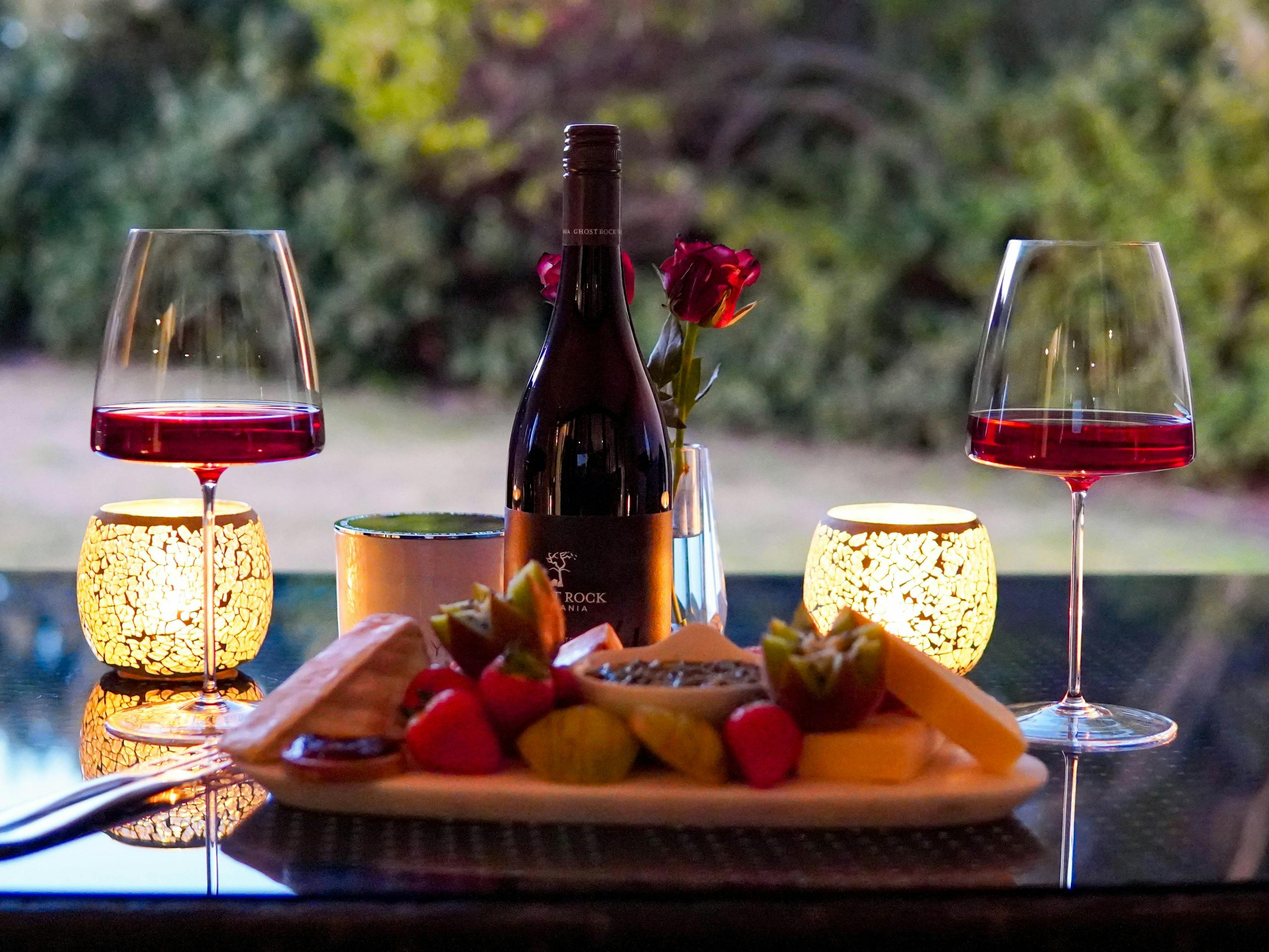 A cheese platter and two glass a red wine