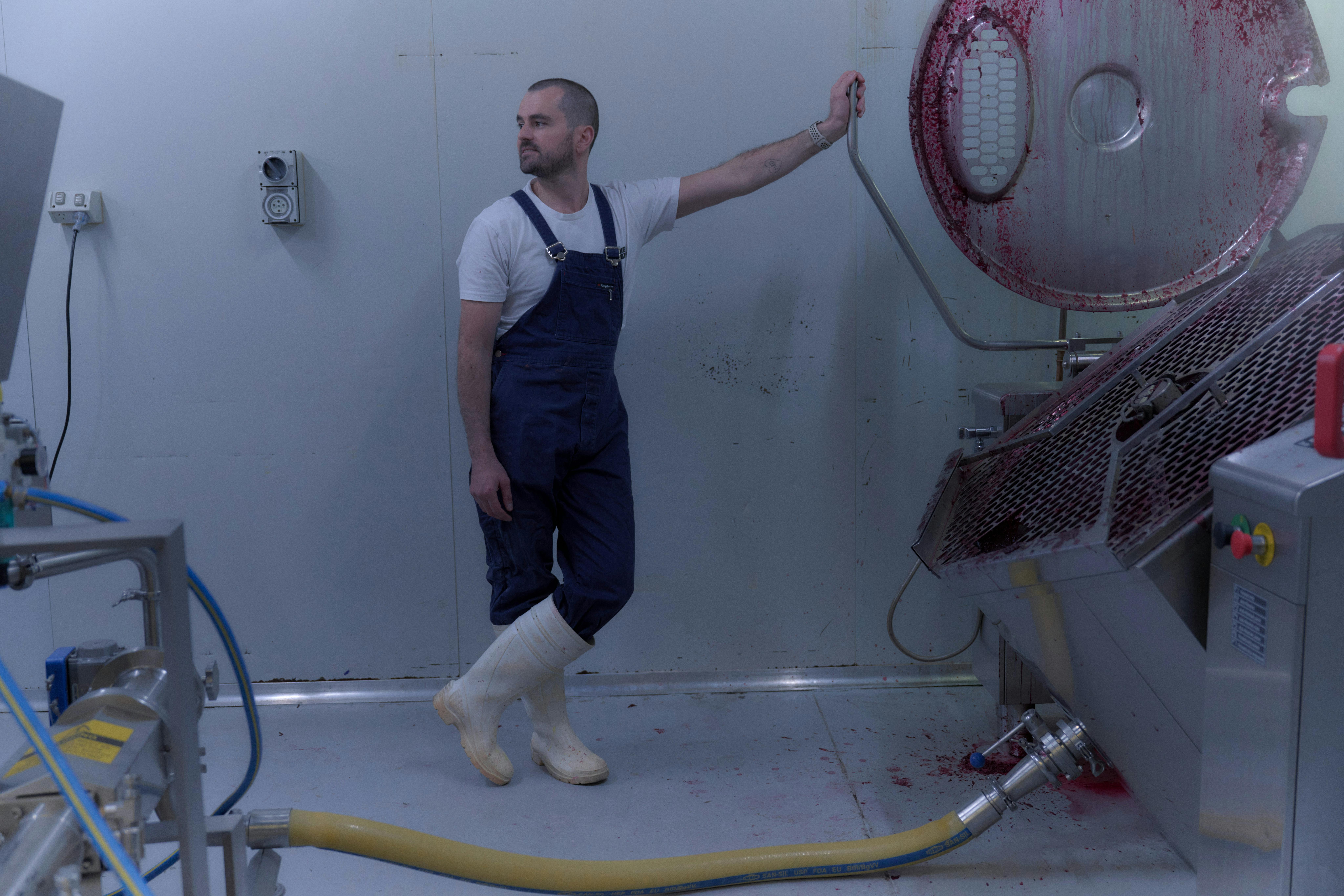 Man in a navy apron standing in an industrial food producing space