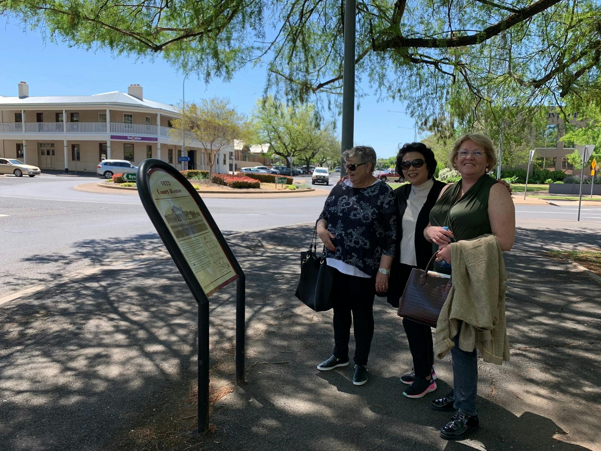 3 guests reading heritage information board