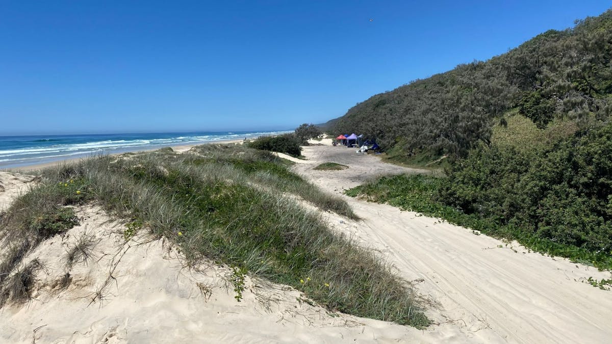 Coloured marquees set up behind the sand dunes.