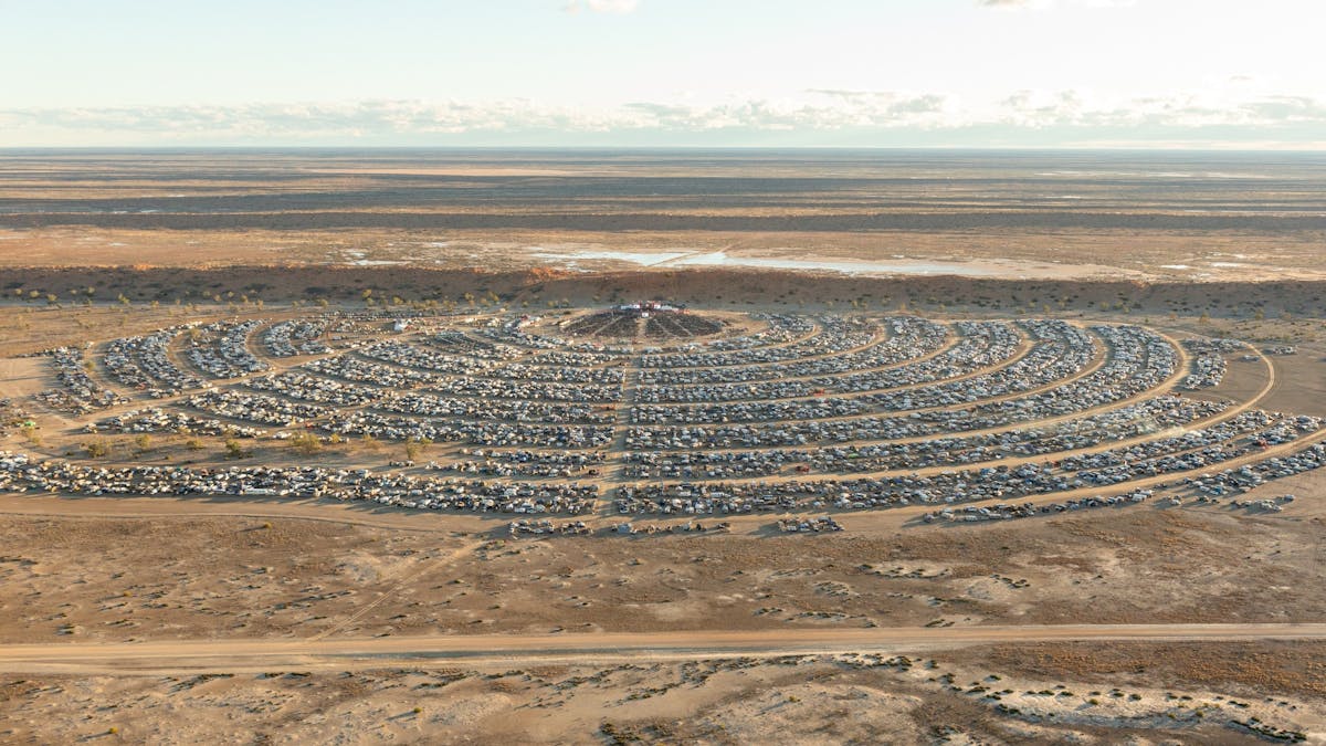 Aerial view of Birdsville Big Red Bash campground stretching across the Simpson Desert, Queensland