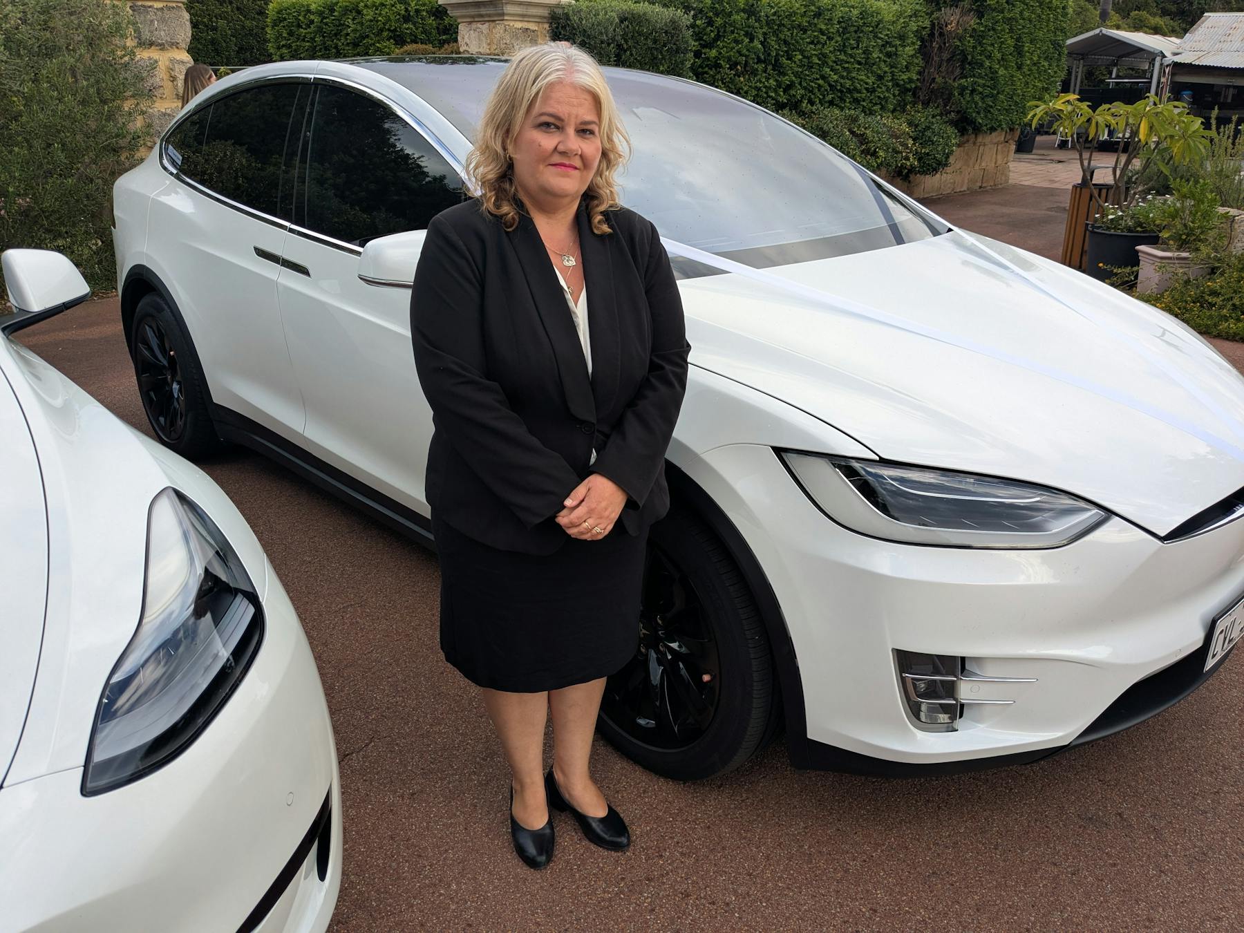 Tesla Model X and female chauffeur at Caversham House