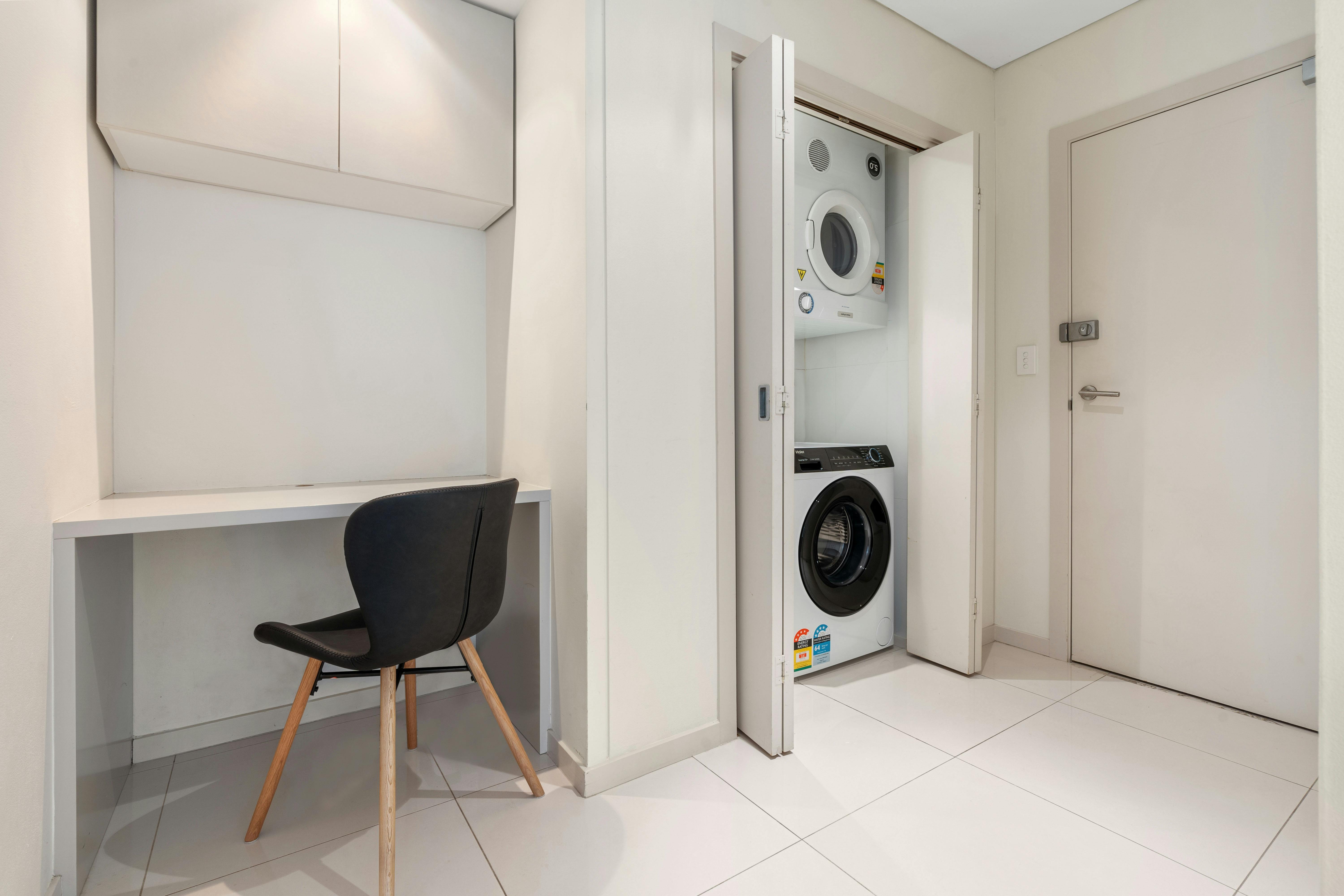 Efficient work nook and laundry combo in a compact space.