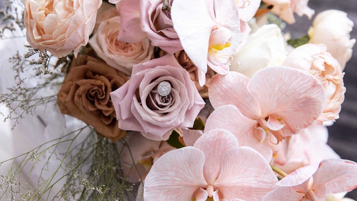 A bridal bouquet of roses and phaleanopsis orchids.  In varying pink, nude and coffee tones.