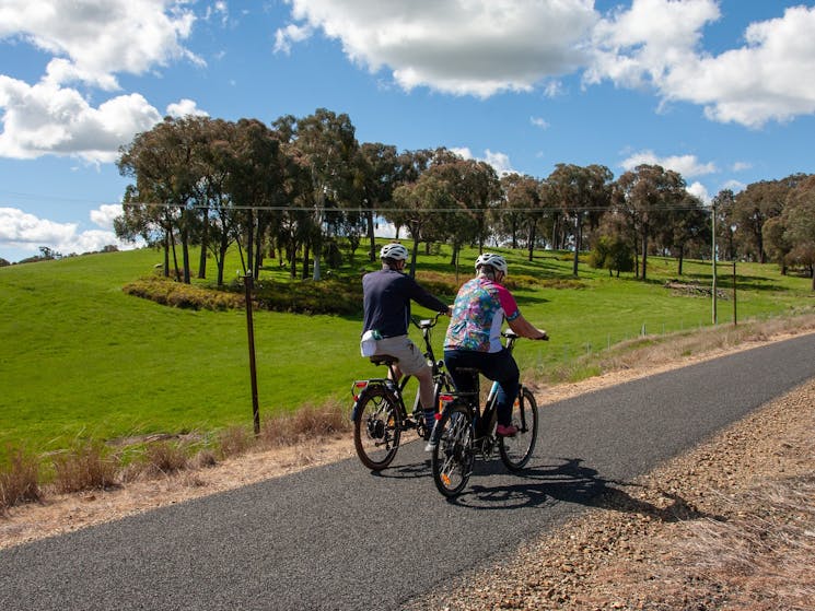 Riders riding uphill on the TUmbarumba Rosewood Rail Trail.