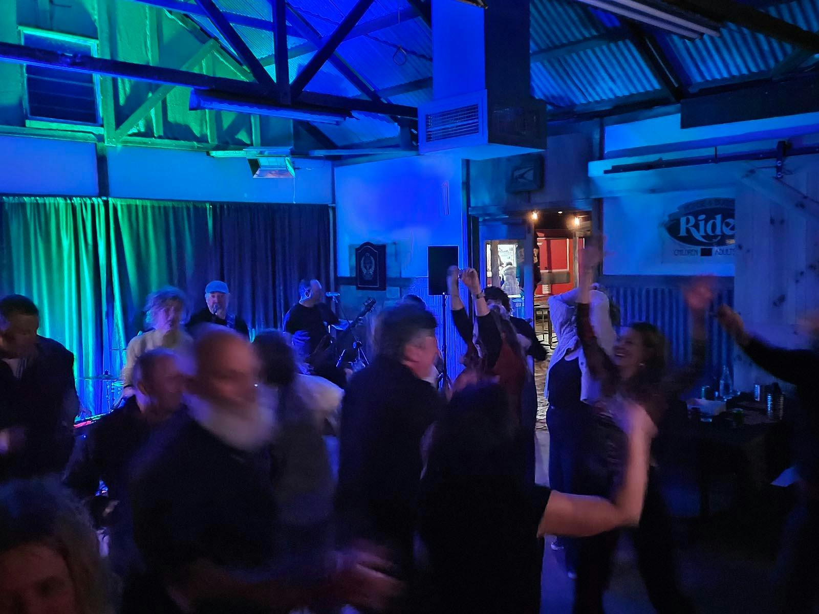 People dancing to the Double Agents Band inside the Barney's band room