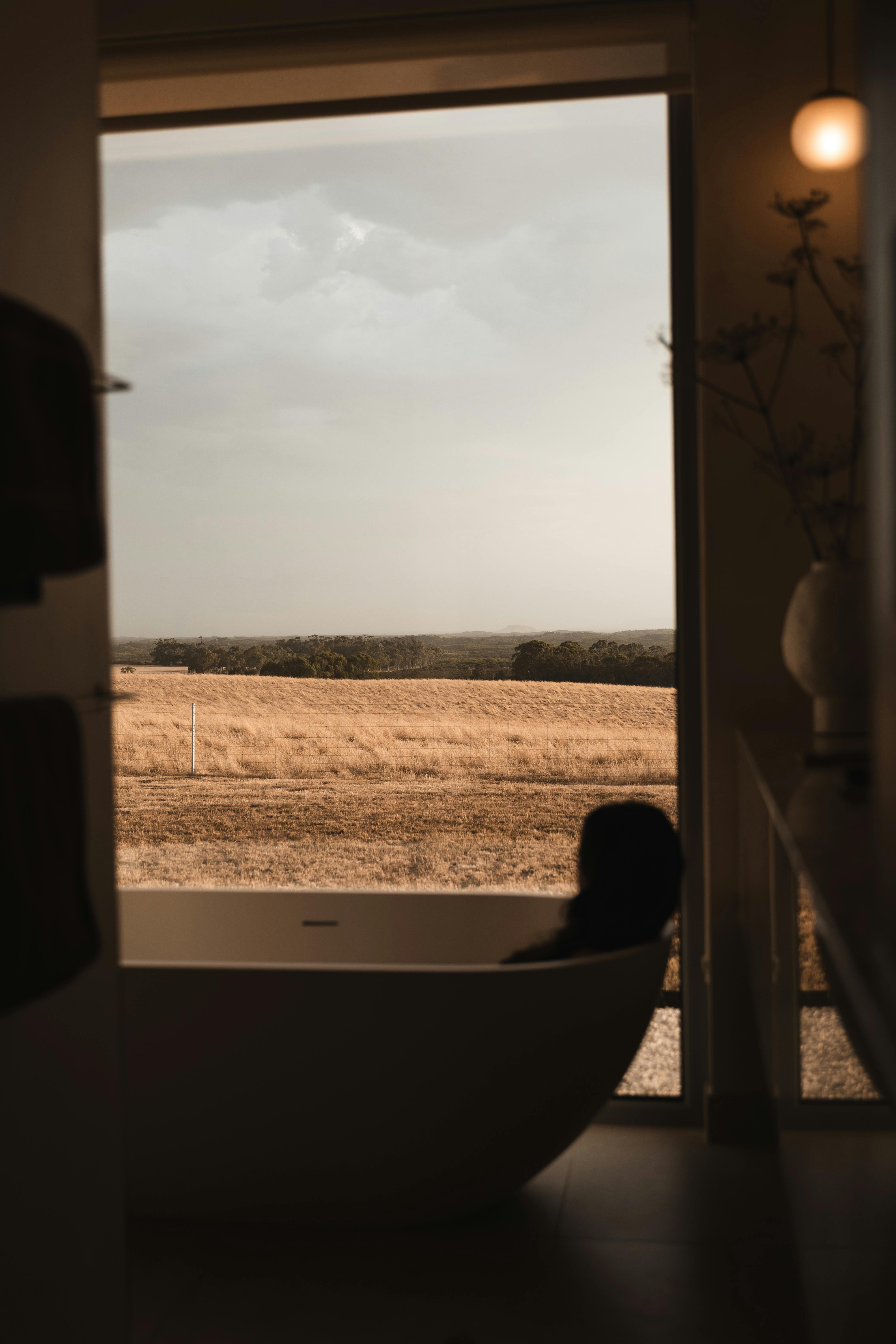 Lady sitting in bath looking out to view
