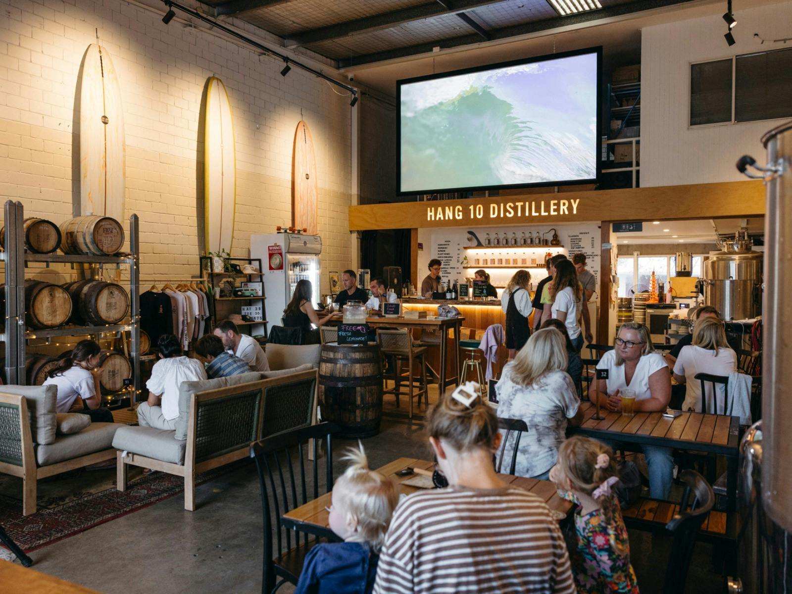 Inside the distillery with a bunch of people on tables enjoying themselves