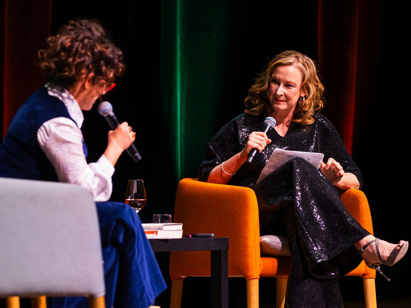 Annabel Crabb und Leigh Sales sitzen auf Sofas auf der Bühne und halten Mikrofone.