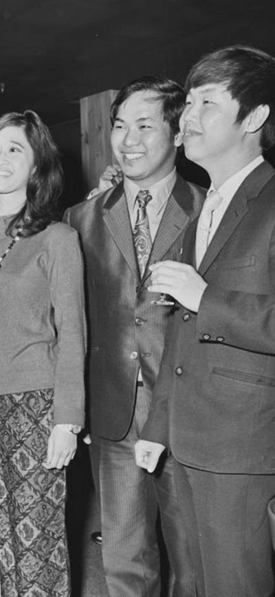 Four men and a woman in conversation while wearing business attire.