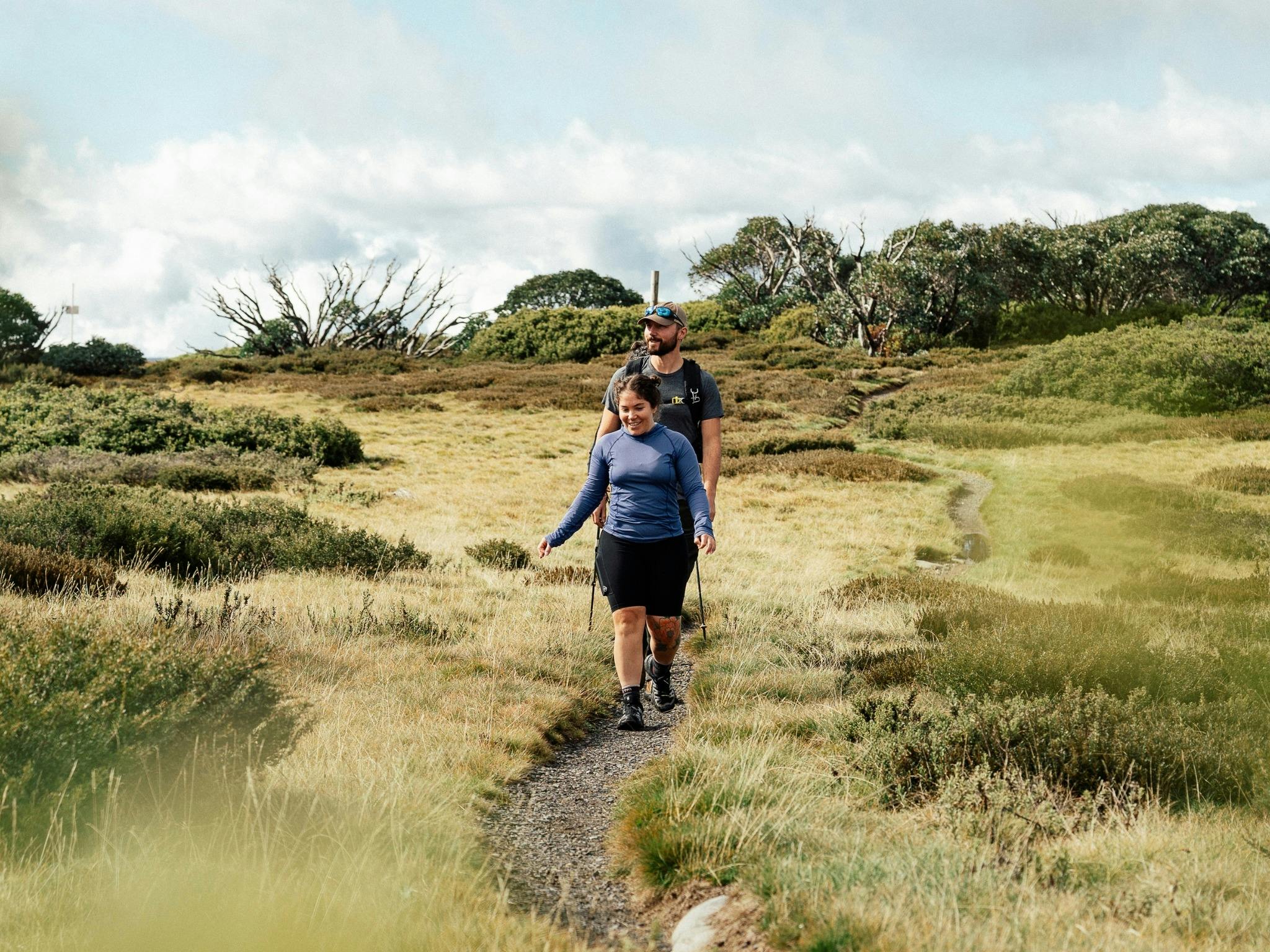 2 hikers walking the single mountain track on open scenery